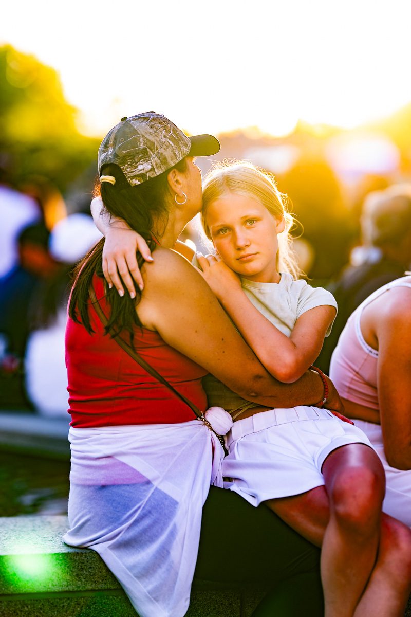 Mother holding daughter in golden sunset light on the grounds of the 2025 US Open.