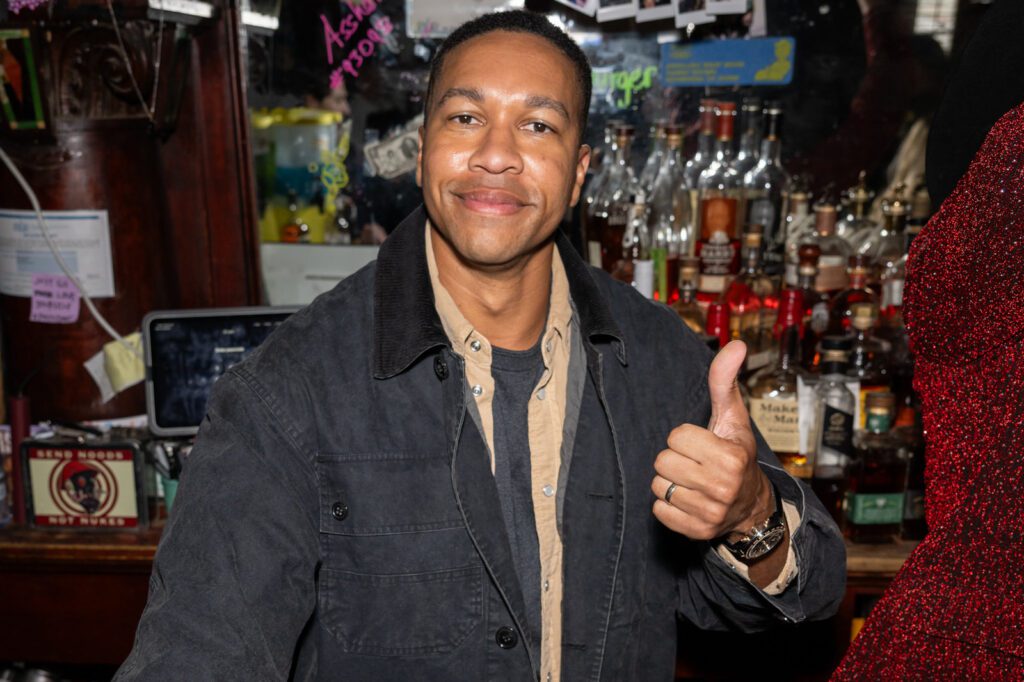 A man gives a thumbs-up gesture while standing behind the bar during the Fallout-themed event.