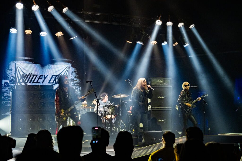 Early part of the show recreating Mötley Crüe’s Sunset Strip roots, with incandescent lighting, vintage fixtures, and a gritty low-angle concert view.