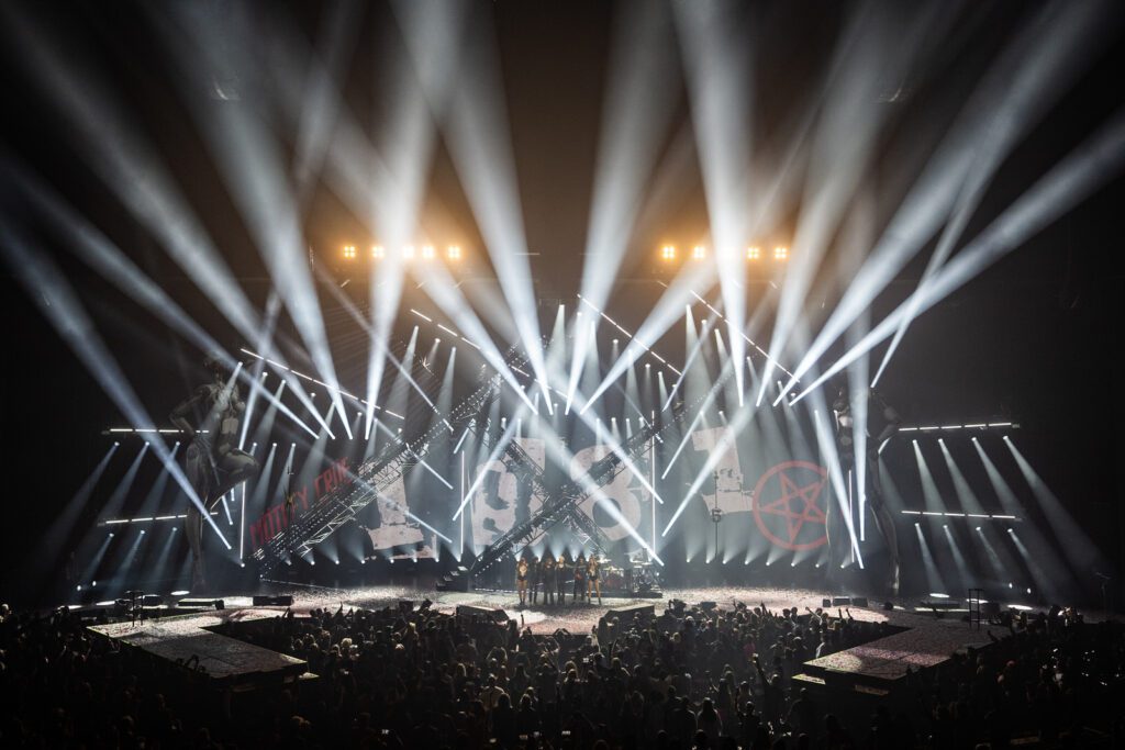 Finale moment from Mötley Crüe’s Park MGM show with intense white beam lighting filling the arena, perfectly symmetrical from rear of house.