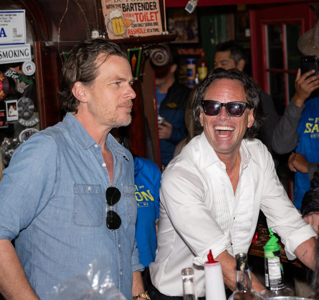 Two men laugh and talk at the Pioneer Saloon bar during the Fallout-themed celebration.