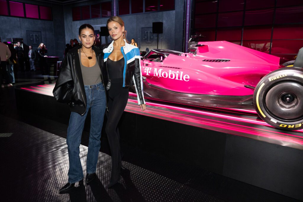 Attendees posing beside the pink T-Mobile Formula 1–style display at the Switching Made Easy event.