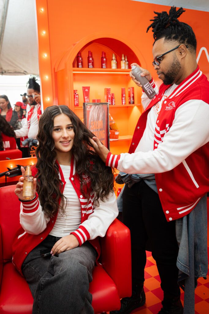 Joanne Ciconte seated at a Wella Professionals pitstop while a stylist finishes her hair