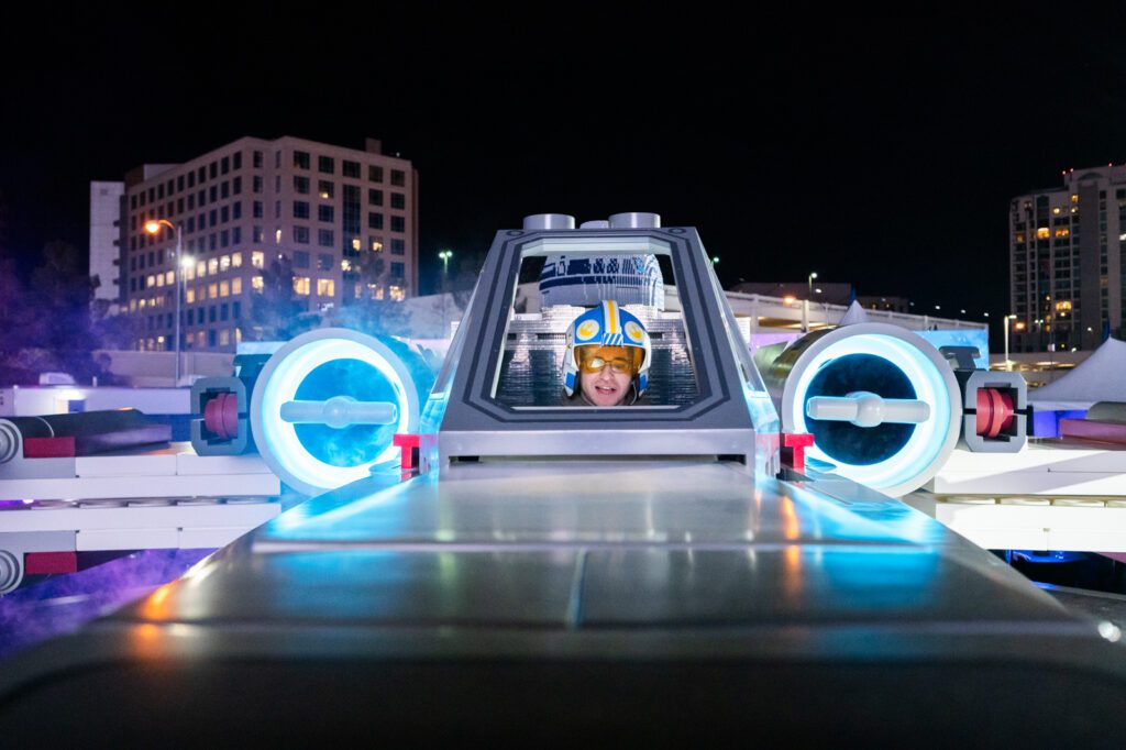 Front view of the LEGO Star Wars X-wing cockpit with glowing engines during the SMART Play activation at Sphere Las Vegas