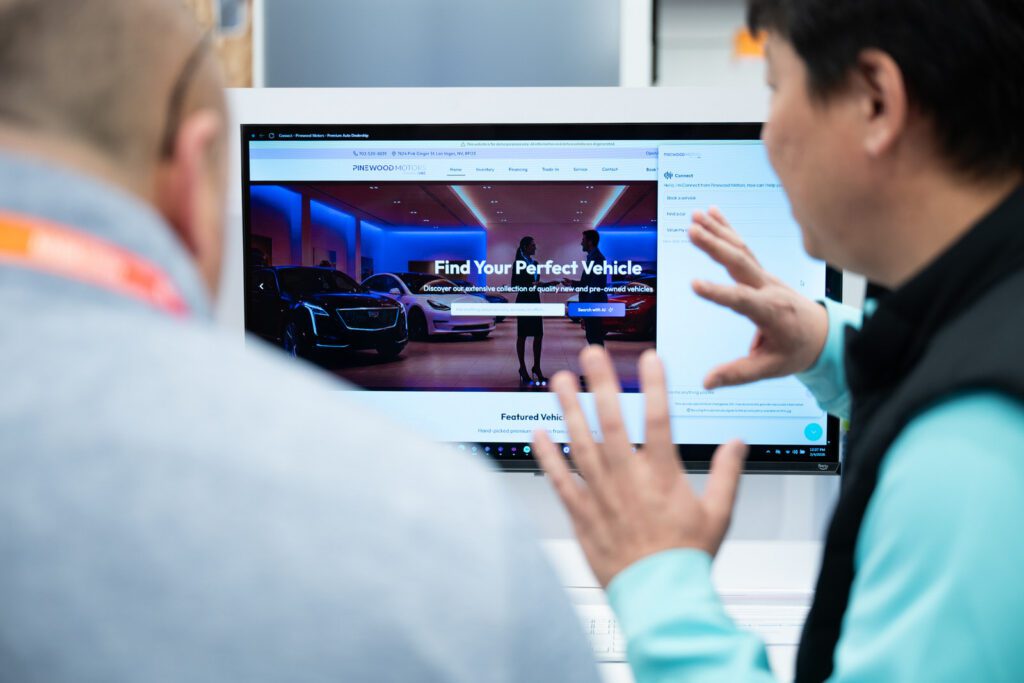 Pinewood.AI team member walking an attendee through a live Connect platform demo on screen at NADA 2026 in Las Vegas