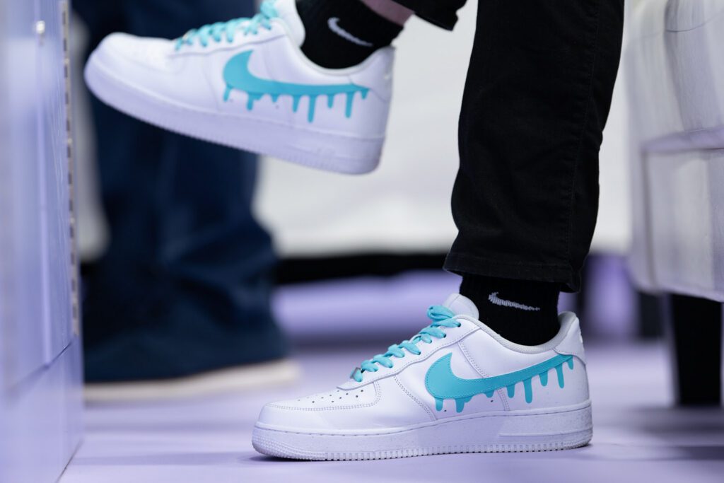 Close-up of custom teal Nike Air Force 1 sneaker worn as part of the Pinewood.AI team uniform at NADA 2026